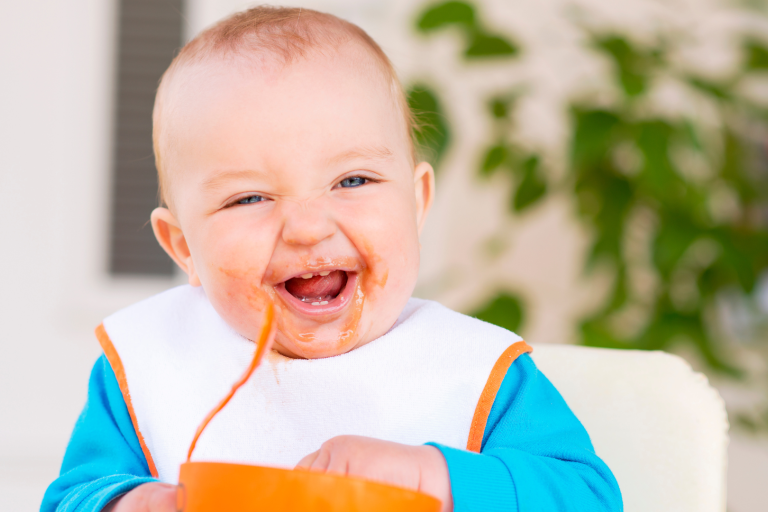 baby eating food with a spoon