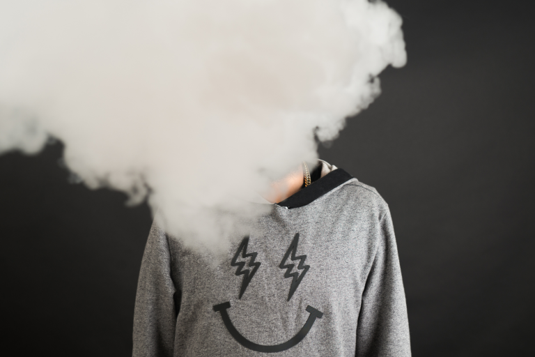 Boy vaping with face covered in smoke