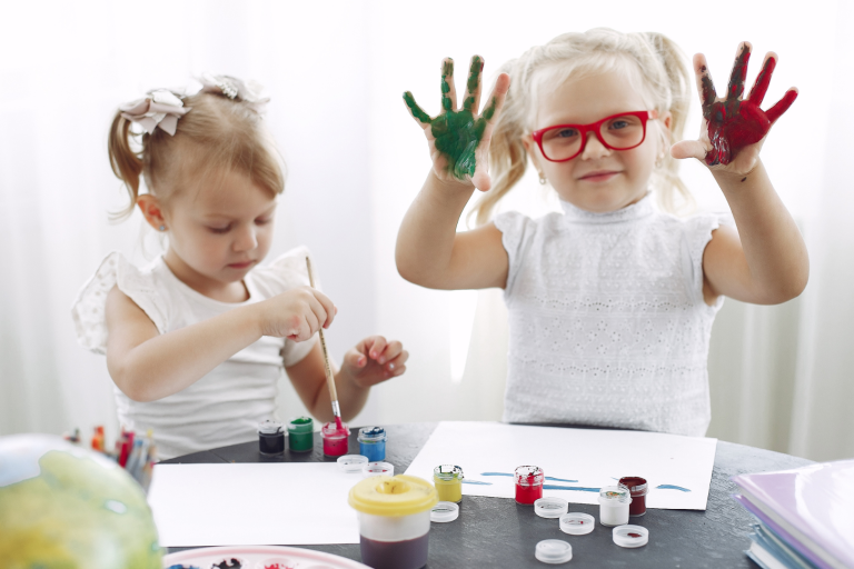 Young children playing with paint on their hands