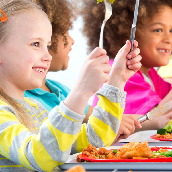 Children eating a meal holding knife and fork